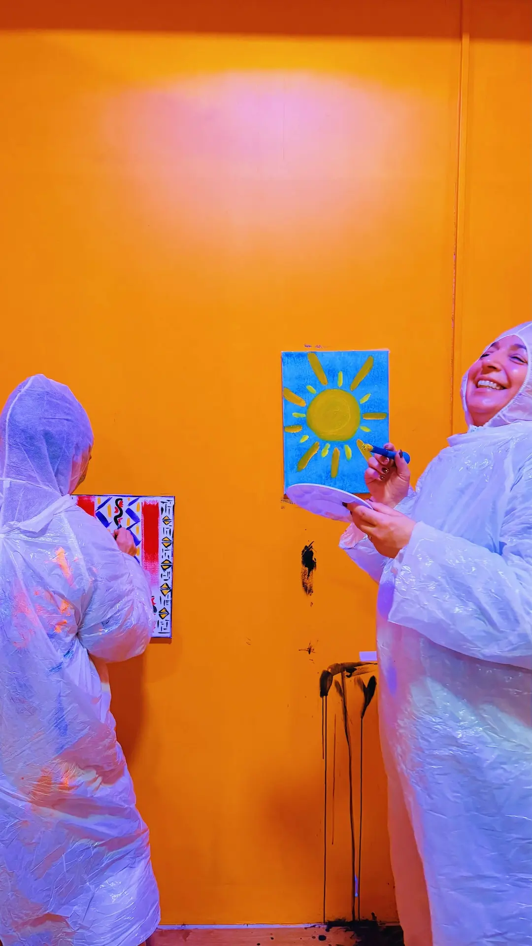 Participantes a pintar uma tela com um sol